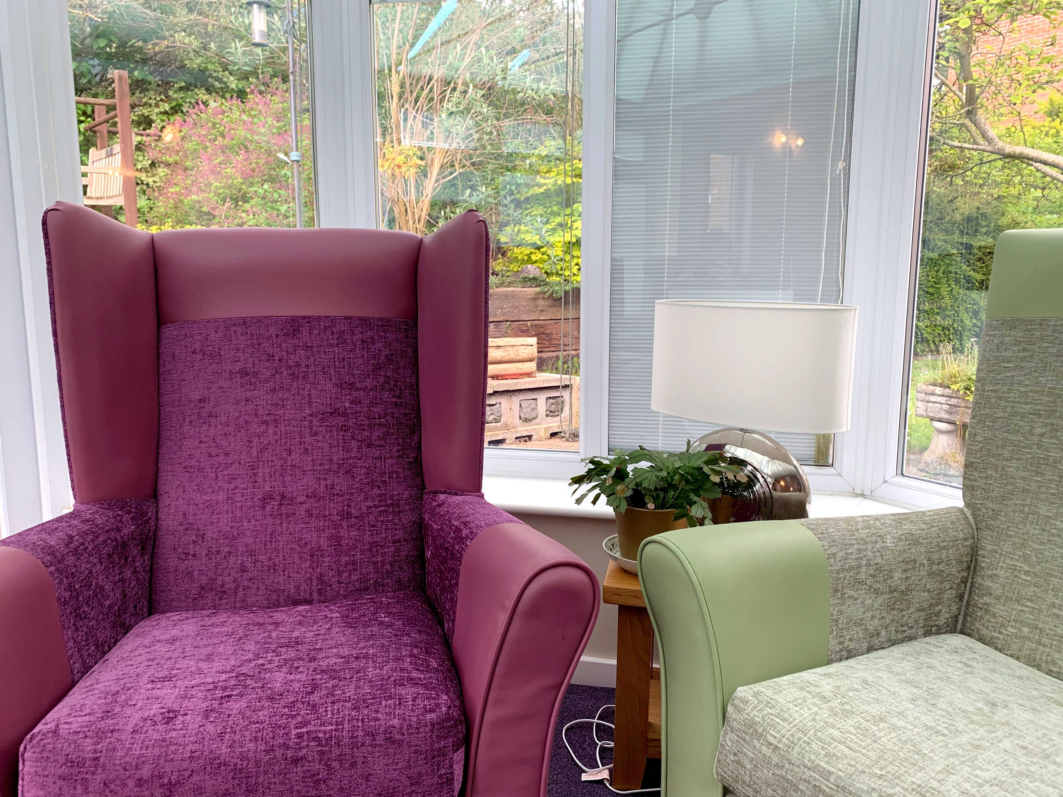 Comfortable armchairs in the conservatory overlooking the garden at Garrad House