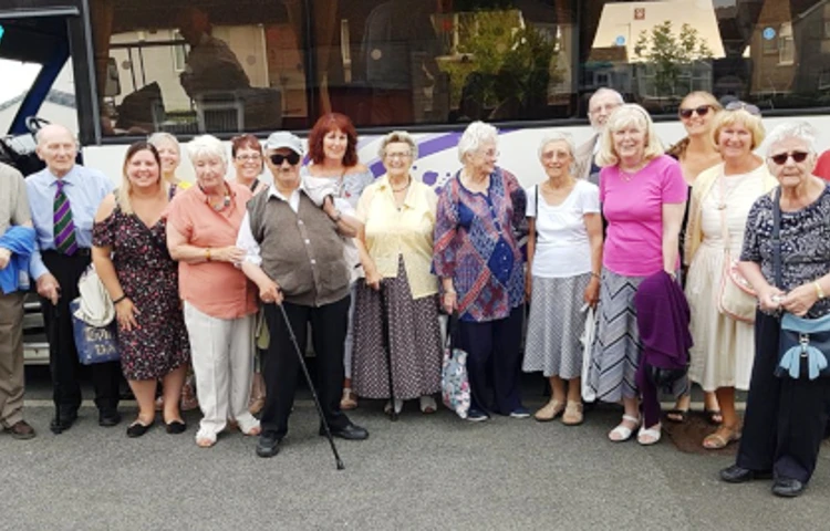 A group of residents standing outside a coach