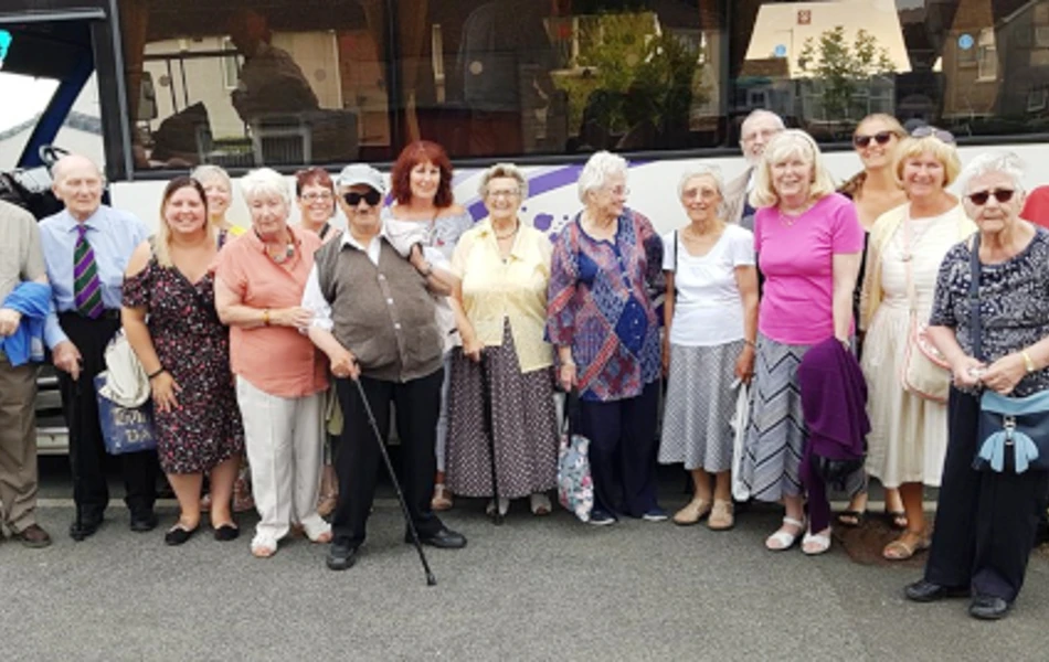 A group of residents standing outside a coach