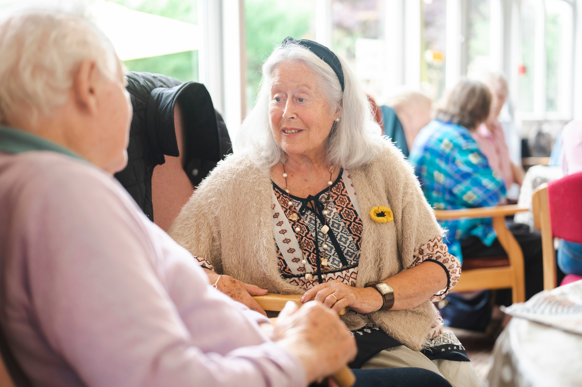 Older Man And Woman Sitting Together Chatting Indoors