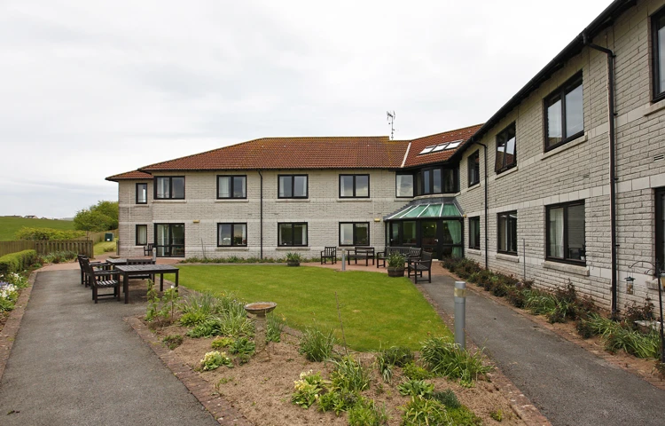 External view of Staveley House gardens with benches and tables