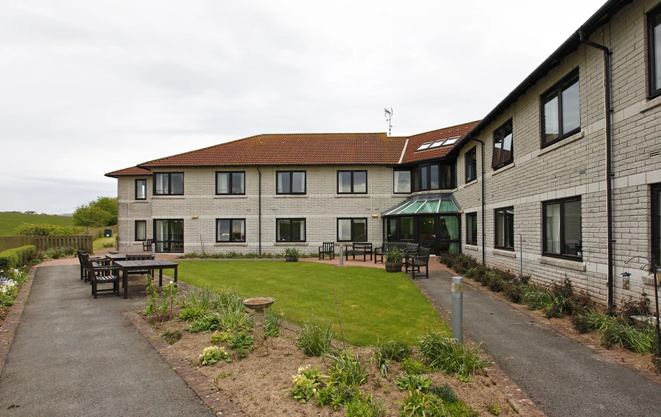 External view of Staveley House gardens with benches and tables