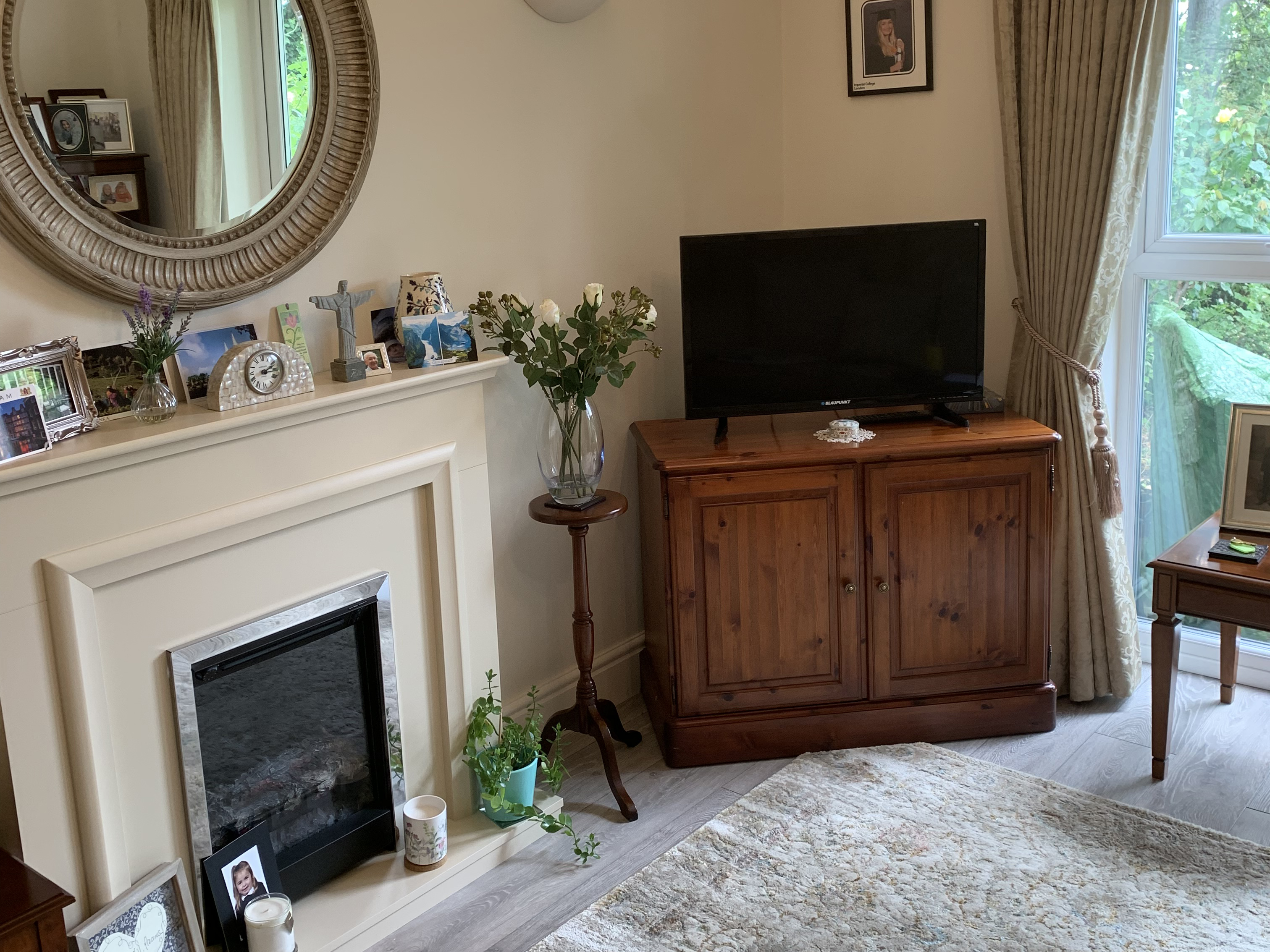 An Abbeyfield residents cosy living room with traditional fireplace and television