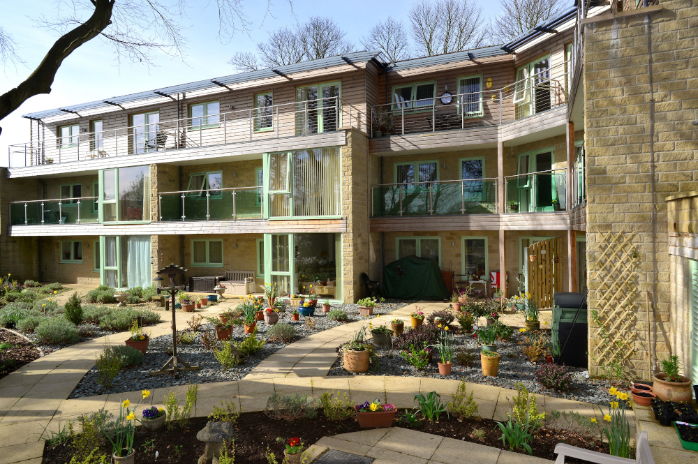 Outside garden area with bird table and colourful plants at Ing Royde,