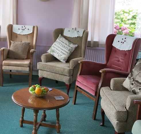 Plenty of comfy chairs and fruit on table in the residents lounge
