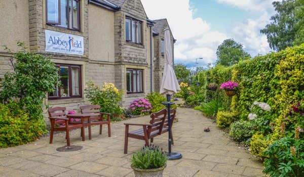 Beautiful bright garden with pink flowers and bench at Castle View House, BB7 2DT