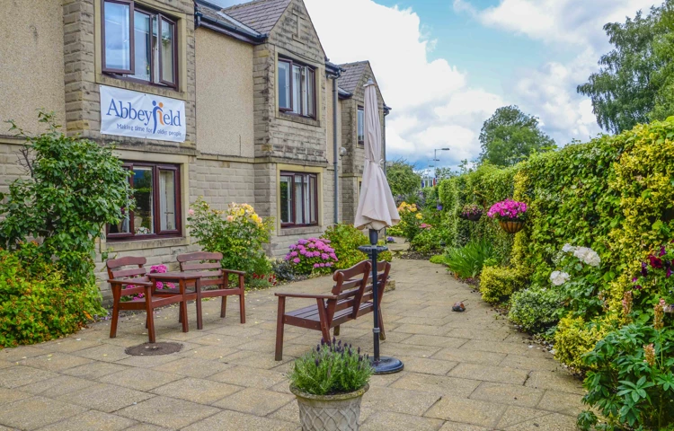 Beautiful bright garden with pink flowers and bench at Castle View House, BB7 2DT