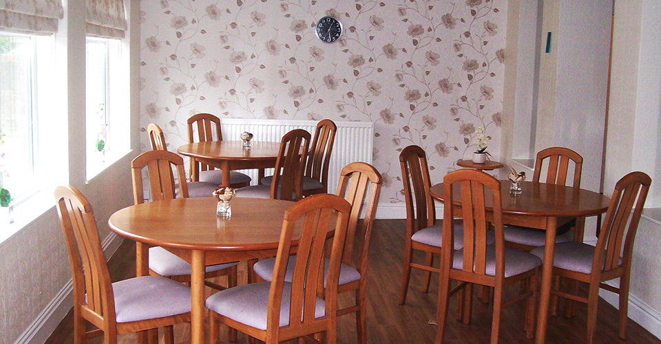 Dining area with tables and chairs and flowered wallpaper