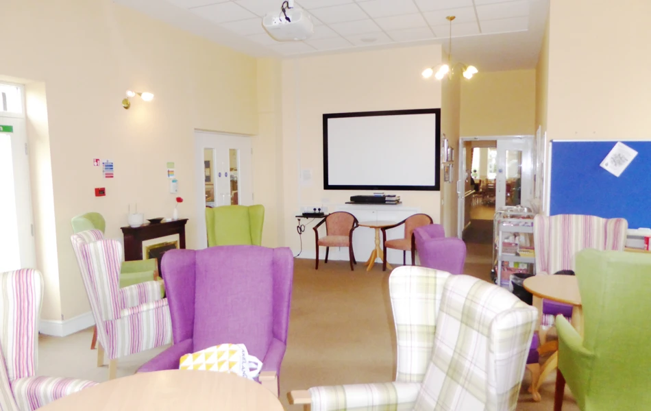 Large bright dining area with coloured chairs