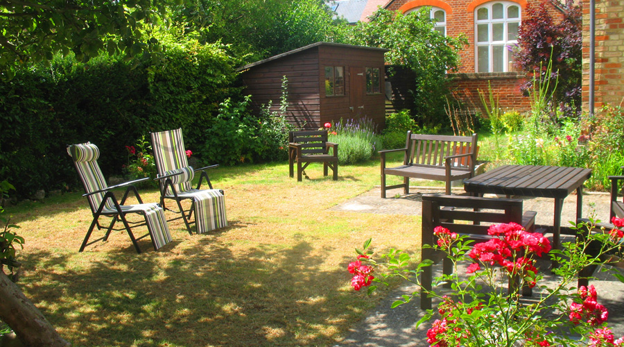 Sunny garden with tables and chairs where residents can enjoy the sunshine and a breath of fresh air