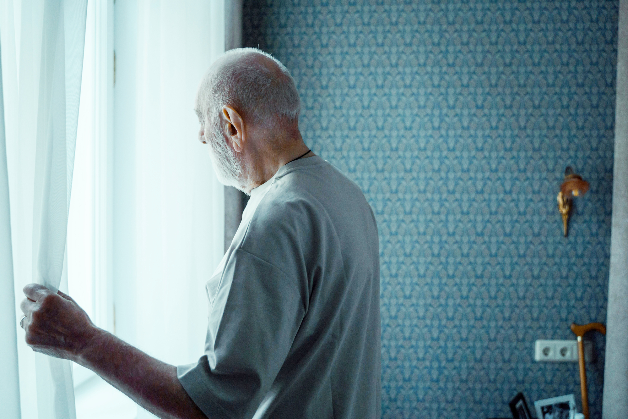 Older Man Looking Out Of Window