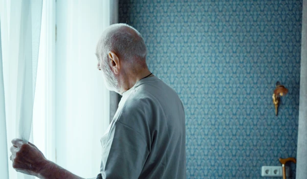 Older Man Looking Out Of Window