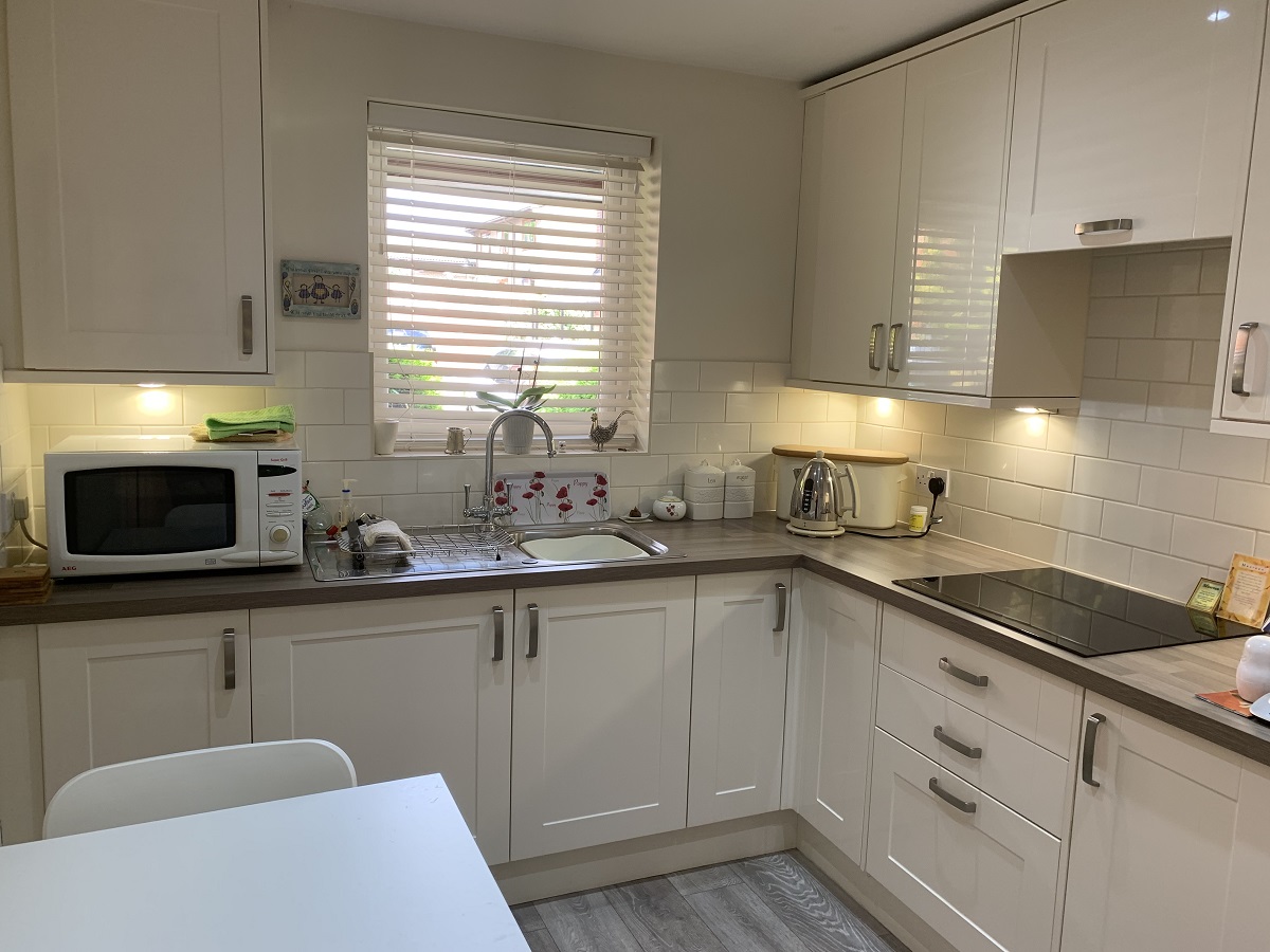 Internal view of a bright white modern kitchen at The Firs Complex