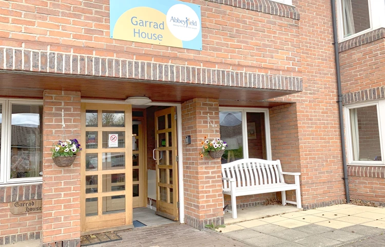 Front exterior of Garrad House with bench outside