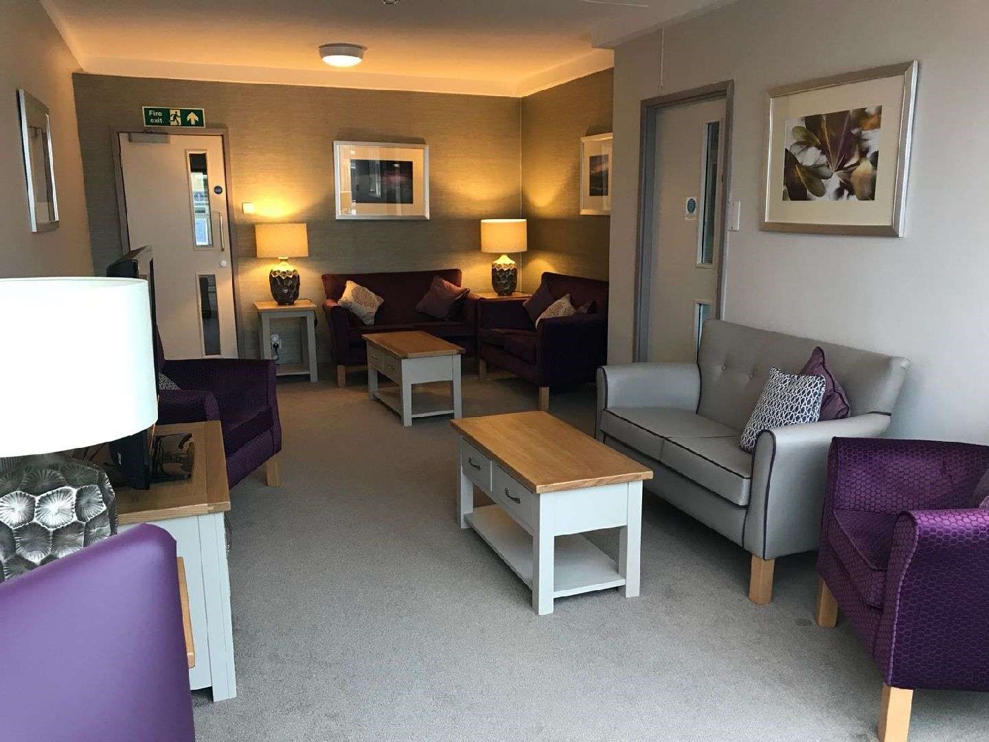 A modern lounge area with purple and grey chairs